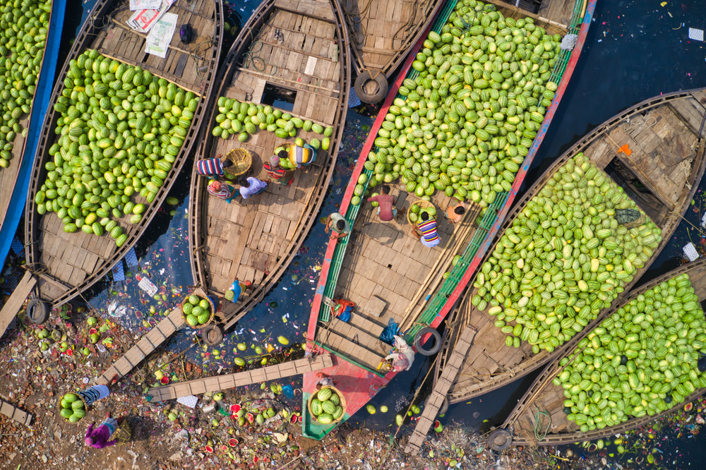 Workers unload watermelons from the boats using big baskets von Azim Khan Ronnie