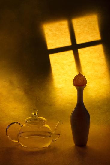 Still life with a teapot and a vase on a window background