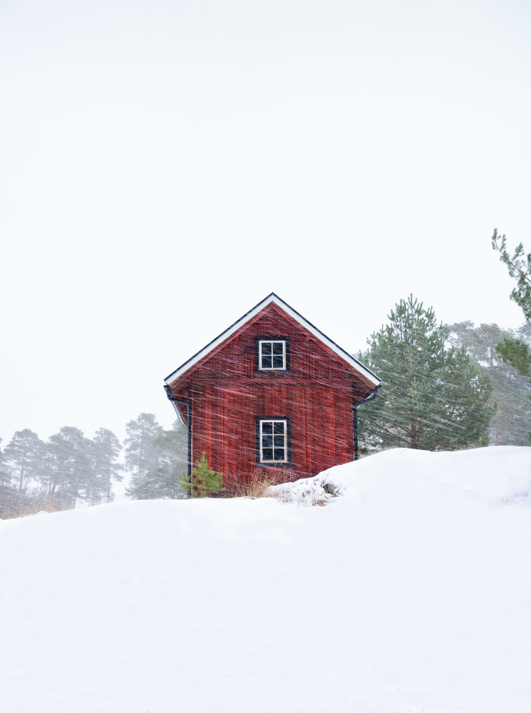 Old red house during snowstorm von Christian Lindsten