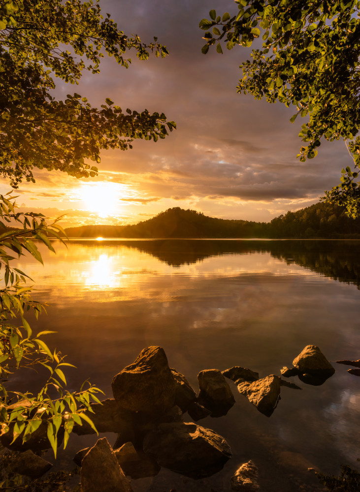 Sunset at a lake with a small mountain in the background von Christian Lindsten