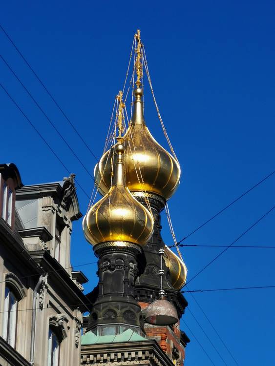 Goldglänzende Kirchtürme vor blauem Himmel in Kopenhagen von Doris Beckmann