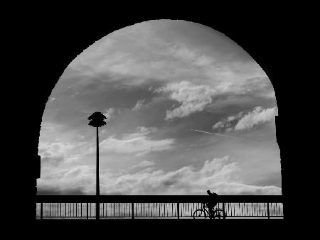 Cyclist, clouds and street lamp in the arch