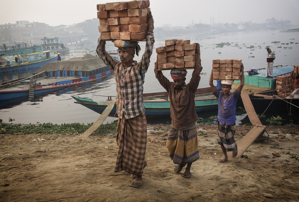 transporting bricks at Biruganga riverbank von Elena Molina