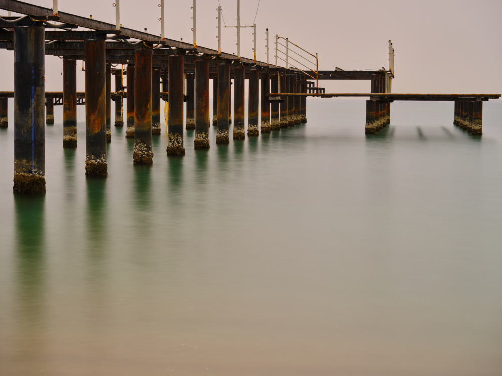 old pier on the beach and long exposure sea waves von engin akyurt