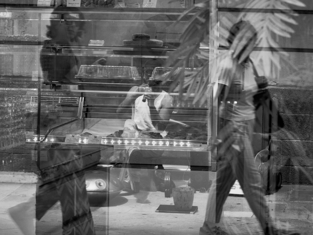 Street artist reflected in the shop window von Gianni Bredice