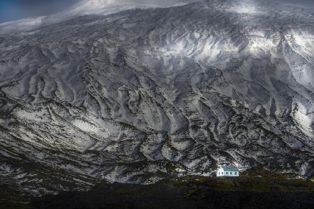 A house at the foot of a snowy mountain