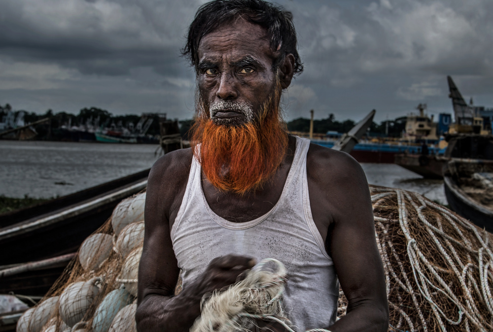 A man from Bangladesh untangling nets. von Joxe Inazio Kuesta Garmendia