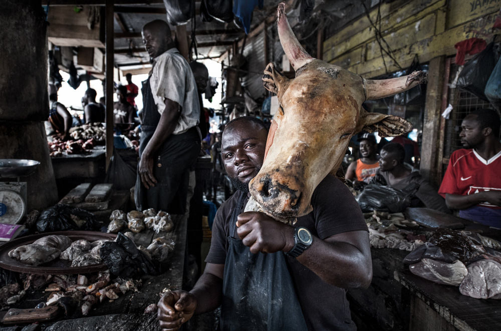 A butcher with a cows head - Ghana von Joxe Inazio Kuesta Garmendia