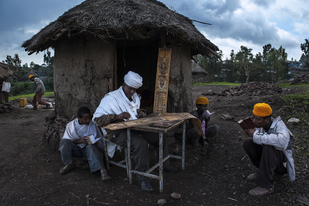 A priest is painting while some guys are praying (Lalibela - Ethiopia) von Joxe Inazio Kuesta Garmendia