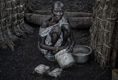 El Molo ethnic woman feeding the chickens