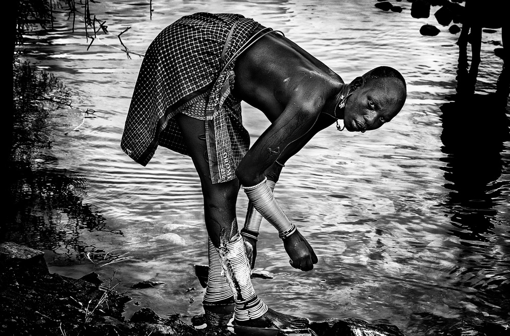 Surma tribe woman washing up her jewelry - Ethiopia von Joxe Inazio Kuesta Garmendia