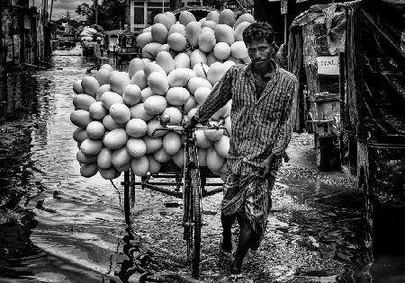 Carrying goods through flooded streets in Bangladesh