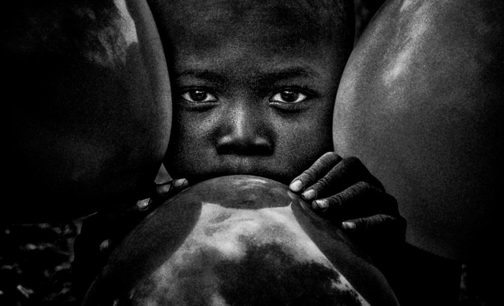 Surma tribe child playing with balloons - Ethiopia von Joxe Inazio Kuesta Garmendia