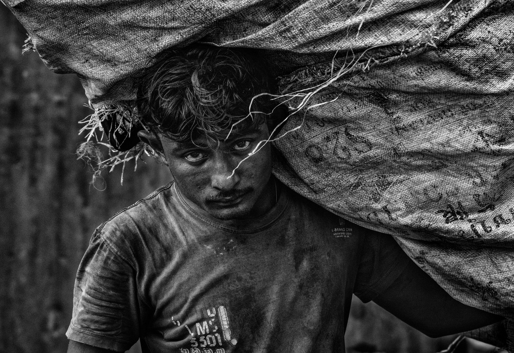 Man carrying an enormous bag of plastic to recycled (Myanmar) von Joxe Inazio Kuesta Garmendia