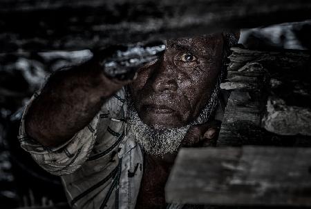 Man tarring the keel of a ship - Bangladesh