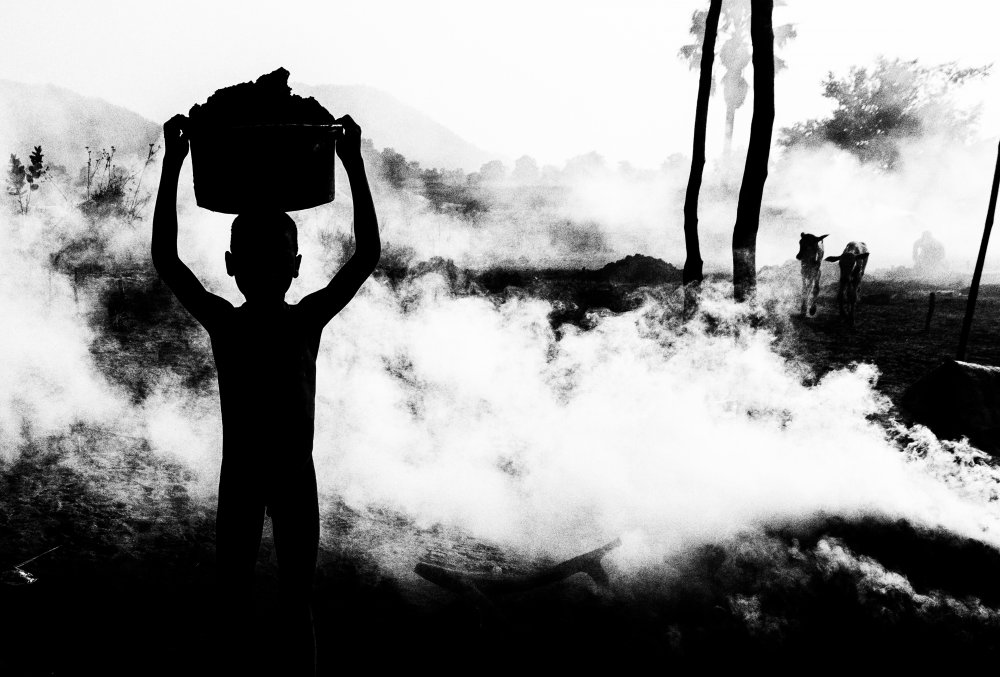 Carrying dung in a mundari cattle camp. von Joxe Inazio Kuesta Garmendia