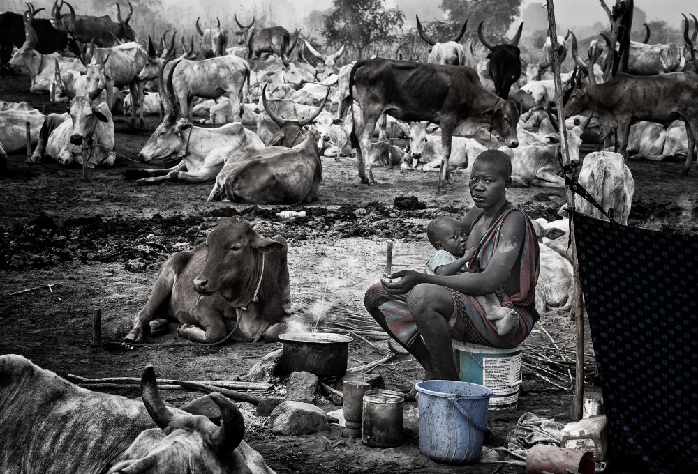 Mundari woman breastfeeding her child in a cattle camp - South Sudan von Joxe Inazio Kuesta Garmendia