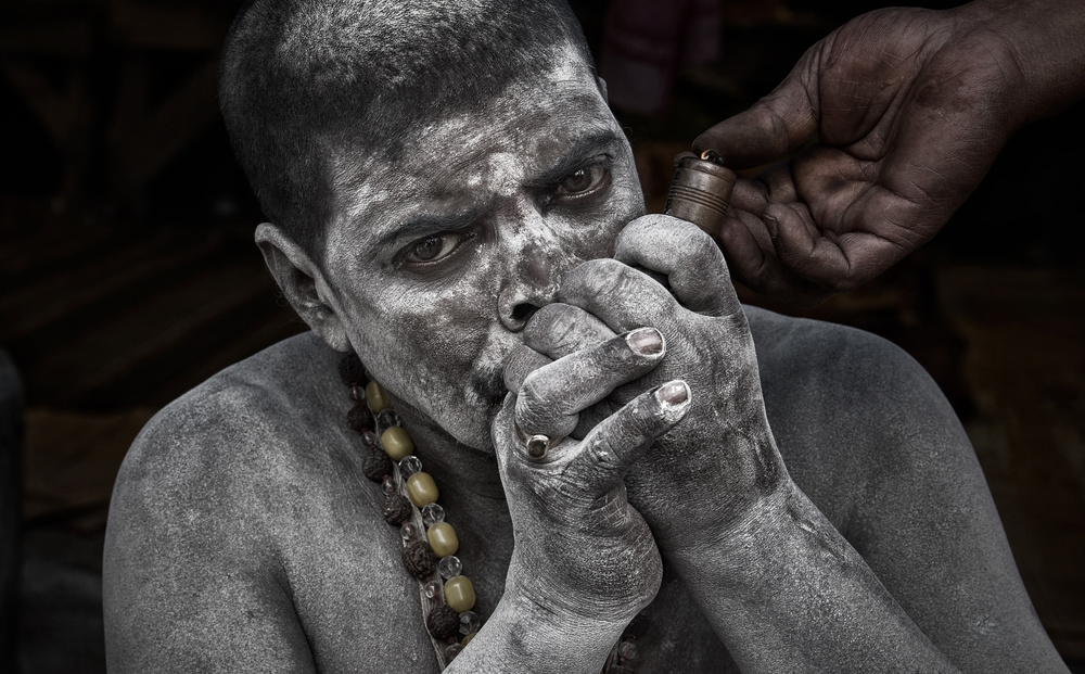 Naga Baba smoking a chilum - Kumbh Mela - Prayagraj - India von Joxe Inazio Kuesta Garmendia