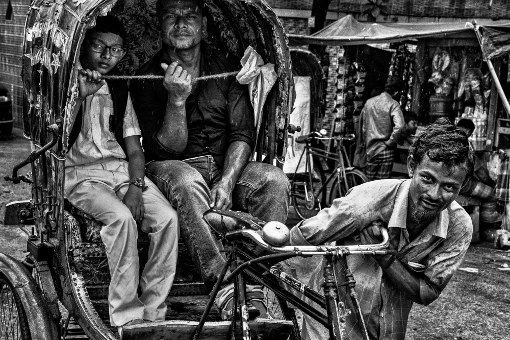 Rickshaw puller with two clients in the streets of Bangladesh von Joxe Inazio Kuesta Garmendia