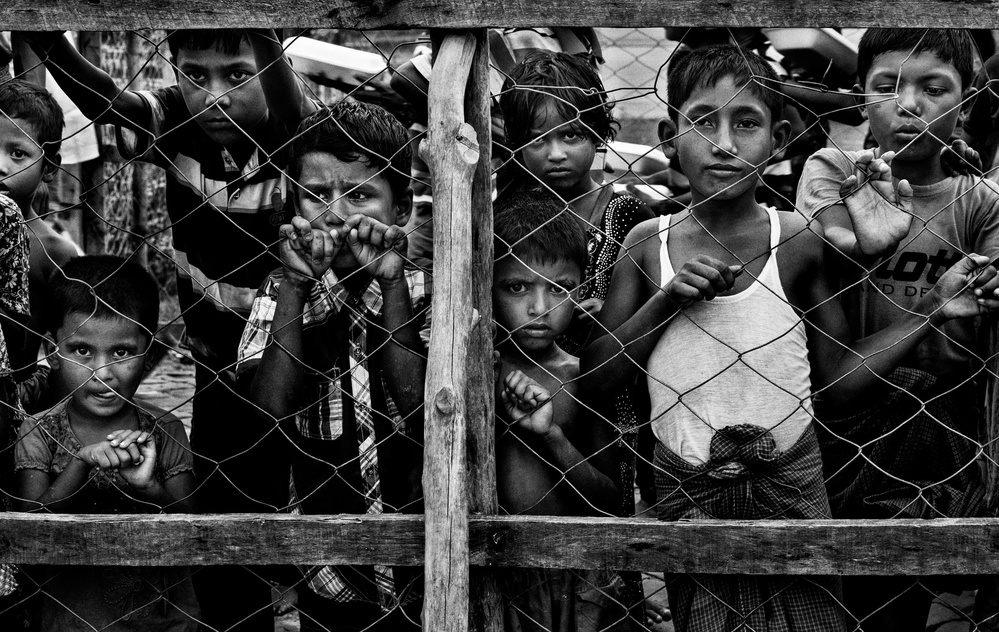 Rohingya children observing the distribution of food in boxes to other children. von Joxe Inazio Kuesta Garmendia