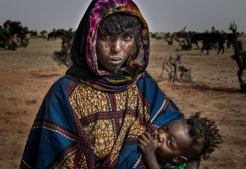 Breastfeeding her child at the gerewol festival - Niger von Joxe Inazio Kuesta Garmendia