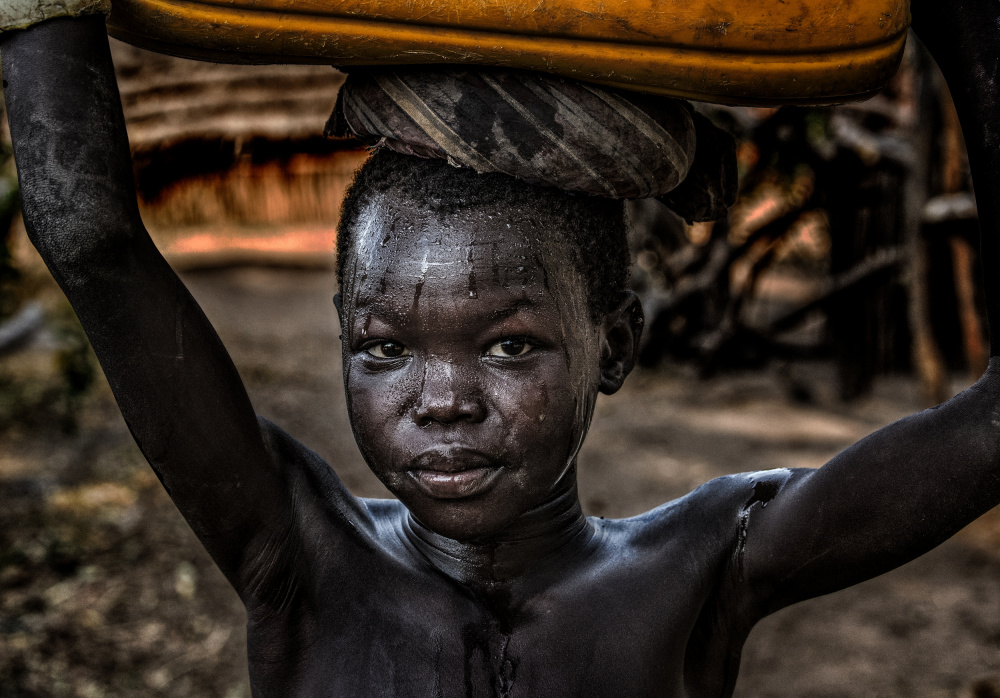 South sudanian child carrying a water containera von Joxe Inazio Kuesta Garmendia