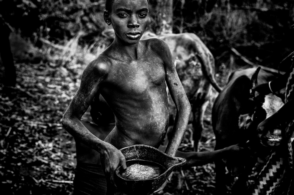 Carrying blood of a calf newly extracted to be drunk-Ethiopia von Joxe Inazio Kuesta Garmendia