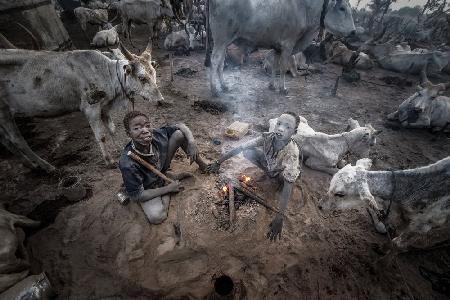 Two mundari children in the heat of a bonfire - South Sudan