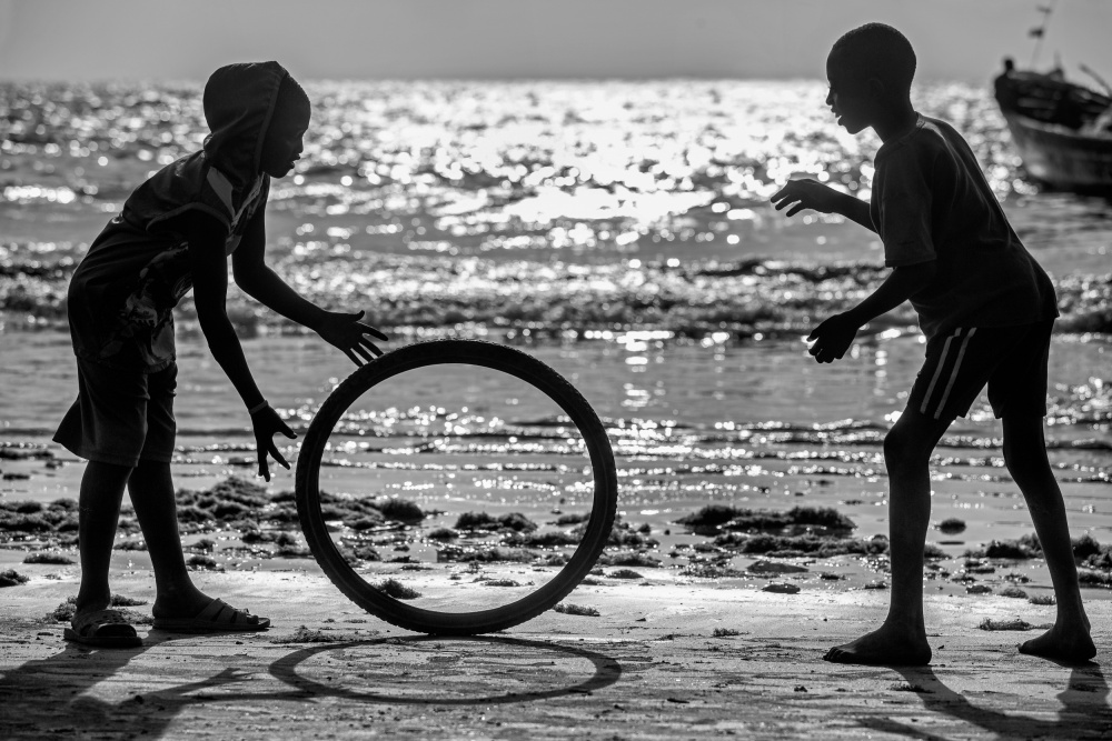 Africa kids playing with old wheel von Milton Louiz