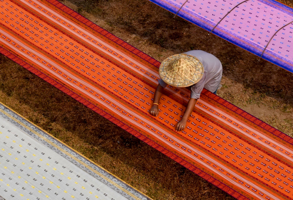 A worker in a saree drying field von Moumita Mondal