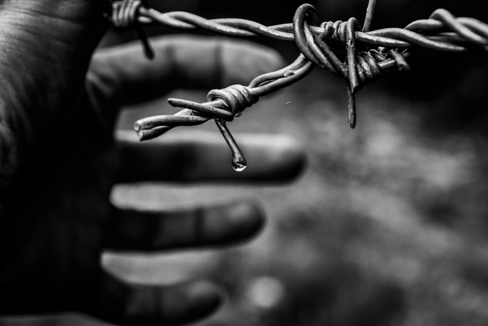 Hand and metal fence BW von RABIA BASHA ARTIST