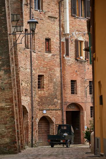 Romantische Altstadtgasse mit Mopedauto in Montepulciano