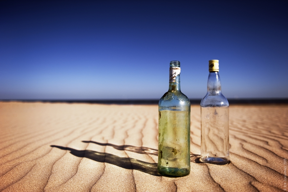 Bottles on sand von Wim Schuurmans